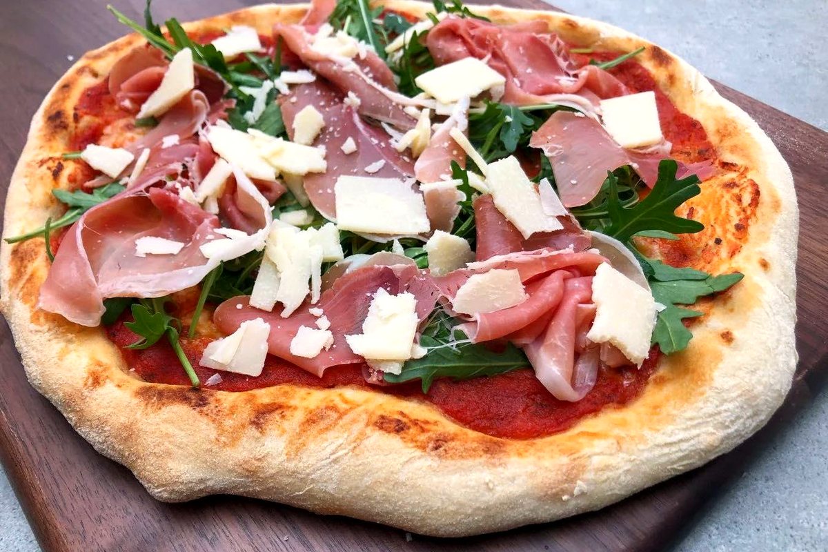 A pizza fresh from the oven, on a wooden board