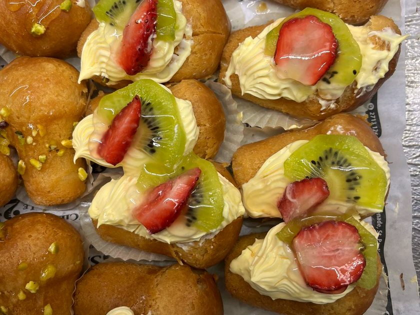 Bomboloni and small tarts filled with crema and topped with strawberry and kiwi