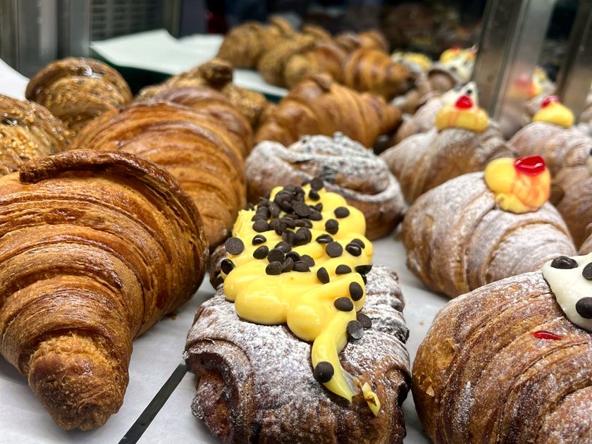 A tray of cornetti — plain, custard-filled and chocolate — dusted with icing sugar