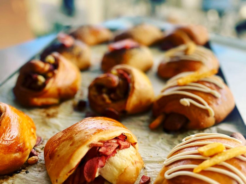 Pastry rolls filled with chocolate, nuts and cured meats on a baking tray